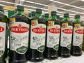 View on isolated italian Bertolli olive oil bottles in shelf of german supermarket Royalty Free Stock Photo