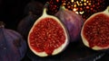 View on isolated raw ripe fig half with group of figs on black slate stone illuminated by oriental candle lamp (fo Royalty Free Stock Photo