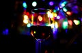 View on isolated shot glass with rum. Bokeh with vibrant colors and blurred bottles background