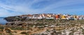 View of the jagged rocky coast and colorful houses in the center of Peniche