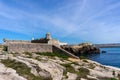 View of the jagged rocky coast and historic fortress in the center of Peniche