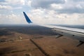 View of jet airplane wing landing at airport in bad weather. Travel and air transportation concept Royalty Free Stock Photo