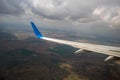 View of jet airplane wing landing at airport in bad weather. Travel and air transportation concept Royalty Free Stock Photo