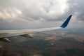 View of jet airplane wing landing at airport in bad weather. Travel and air transportation concept Royalty Free Stock Photo