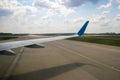 View of jet airplane wing taxiing runway after landing at airport. Travel and air transportation concept Royalty Free Stock Photo