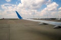 View of jet airplane wing taxiing runway after landing at airport. Travel and air transportation concept