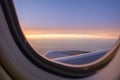 View of jet engine of airplane  from window seat with cloudy sky in sunset light Royalty Free Stock Photo