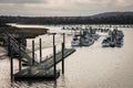 View of a jetty and pier leading to a flotilla of moored yachts on the River Medway in Rochester, England, UK