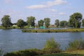 View on junction of river maas with in rural area with rhine maas canal sign dutch text on sign: maas waal canaal from Heumen to