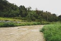 View of Jungle and Mountain Peaks and Small River in Malaysia Rain Forest with Cloudy Stormy Sky. Lush Green Jungle Vegetation and Royalty Free Stock Photo