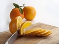View of a knife slicing slices of oranges on a kitchen board
