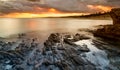 View of La Pelosa beach in Sardinia at sunrise with rocky reef in the foreground Royalty Free Stock Photo