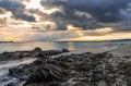 View of La Pelosa beach in Sardinia at sunrise with rocky reef in the foreground Royalty Free Stock Photo