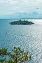 View on Ladoga lake in Karelia with speed boat passing by a green pine trees island shot from a high point with pine tree in frony Royalty Free Stock Photo
