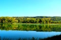 View from Lago Cedri in Lapedona with the surface of water extending over the picture and reflecting vegetation