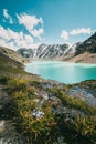 View of Lake Ala Kul and the snow-capped mountains around it on a sunny day in Kyrgyzstan, Central Asia Royalty Free Stock Photo