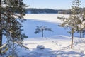 View of Lake Meiko area in winter, snow covered rocks, pine trees and frozen lake, Kirkkonummi, Finland