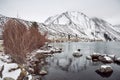 View of Lake on the Mountains in Winter Fog with Dramatic Snow Capped Mountains in the Background Royalty Free Stock Photo