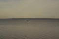 view of Lake Pleshcheyevo with a forested lake shore on the horizon and a boat Royalty Free Stock Photo