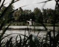 View of a lake surrounded by trees and a scarecrow on the shore.