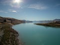 View of Lake Tekapo, New Zealand, with turquoise blue water and sun flare Royalty Free Stock Photo