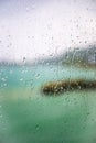 View of the lake through a window with wet glass