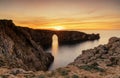 view of the landmark stone arch of Pont d\'en Gil on Menorca Island at sunset