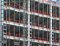 View of a large building development under construction with steel framework and girders supporting the metal floors with safety f Royalty Free Stock Photo