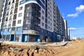 View on the large construction site . Facde of the modern multi-storey residential building.  Use of crane, excavator and Royalty Free Stock Photo