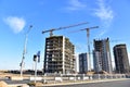 View on the large construction site with tower cranes and buildings on sunset background.  Road work Royalty Free Stock Photo