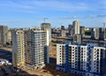 View on the large construction site at urban area. Tower cranes in action with machinery and builders. Multi-storey residential