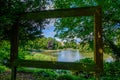 View through large hollow picture frame of pond, trees, ducks and people at Leases Park in Newcastle, England