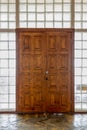 View of a large wooden door in a wall of glass blocks Royalty Free Stock Photo