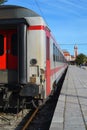 View from the last white passenger train car to the railway station during the day