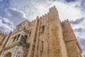 View of lateral facade of the gothic building of Coimbra Cathedral, Coimbra city and sky as background, Portugal