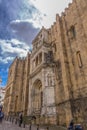 View of lateral facade of the gothic building of Coimbra Cathedral, Coimbra city and sky as background, Portugal