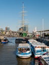 View at launch boats in foreground and green colored sailing ship Rickmer Rickmers and Hafencity with Elbphilharmonie in