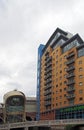 View of leeds with the river aire entering the dark arches under the railway station with pedestrian footbridge and office and