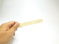 View of left hand holding wooden ice cream stick isolated on white background Royalty Free Stock Photo