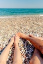 View of the legs of a man and woman who are relaxing on the beach. Royalty Free Stock Photo