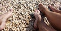 View of legs of young girl and boy on croatian beach, pebble beach, lower part of human body Royalty Free Stock Photo