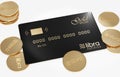 View of Libra gold-black credit card lying on a white background with golden libra coins