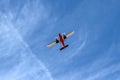 Small Airplane Flying at Low Altitude Under Blue Sky Viewed from Below