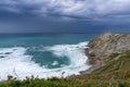 View of the lighthouse on the cliffs at Cabo Vidio under an overcast and stormy sky Royalty Free Stock Photo