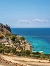 View of Limeni village with fishing boats in turquoise waters and the stone buildings as a background in Mani, Greece