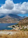 View of Limeni village with fishing boats in turquoise waters and the stone buildings as a background in Mani, Greece