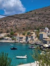 View of Limeni village with fishing boats in turquoise waters and the stone buildings as a background in Mani, Greece
