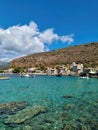 View of Limeni village with fishing boats in turquoise waters and the stone buildings as a background in Mani, Greece