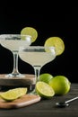 View of limes, lemons and two glasses of margarita cocktail, selective focus, black background, Royalty Free Stock Photo