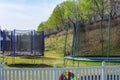View of line of trampolines with saftey net mounted on backyards. Activity concept Royalty Free Stock Photo